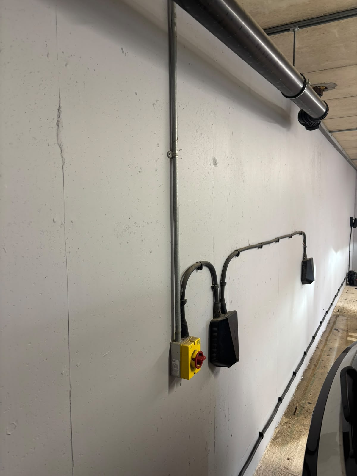 EV charger rotary isolator and supply cable run in a garage