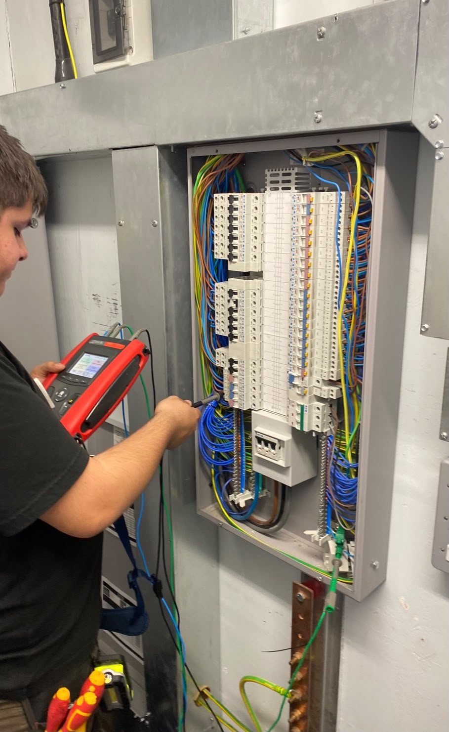 NICEIC engineer testing a commercial three-phase distribution board
