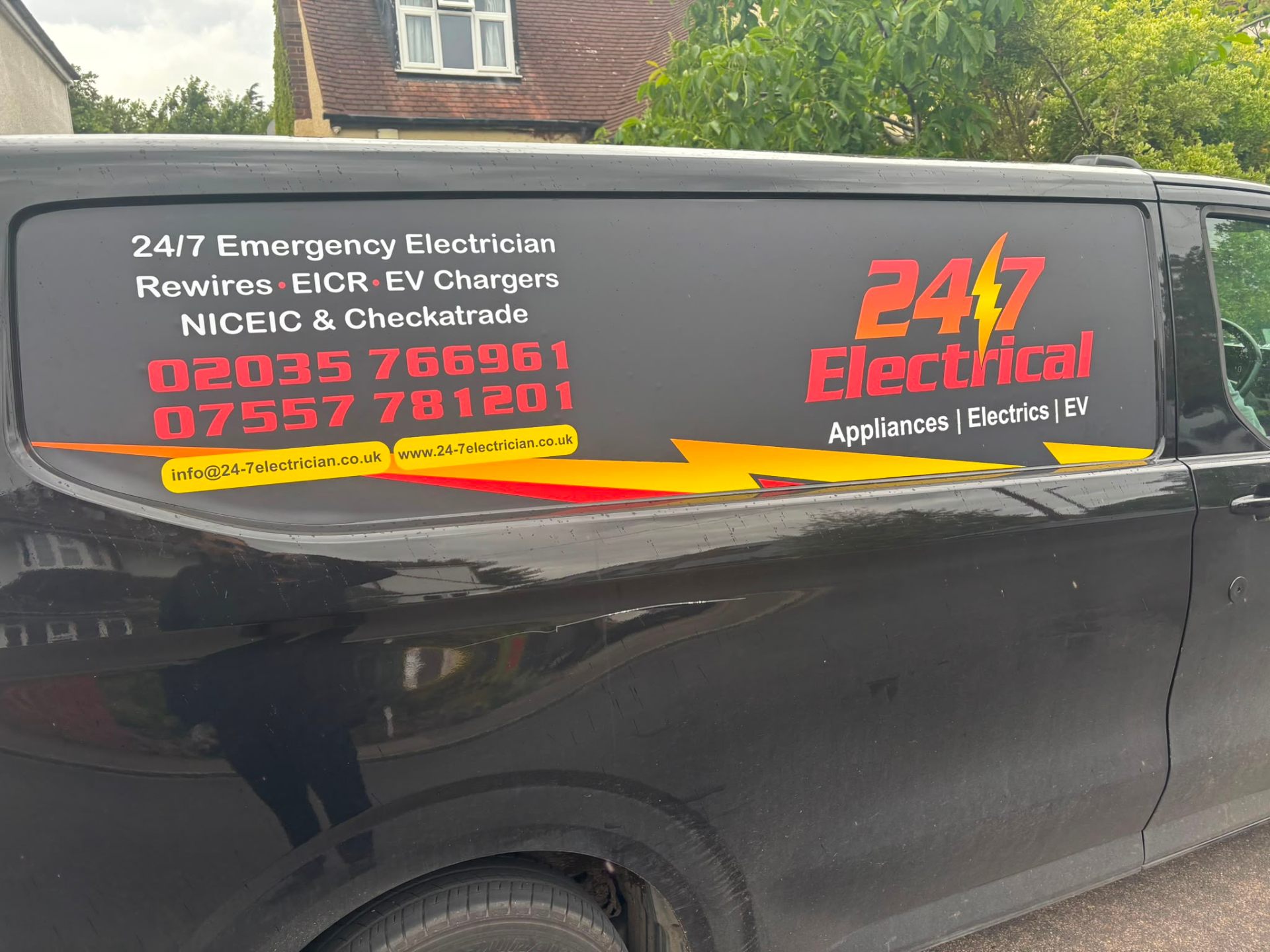 24/7 Electrical signwritten van side panel showing services and phone number