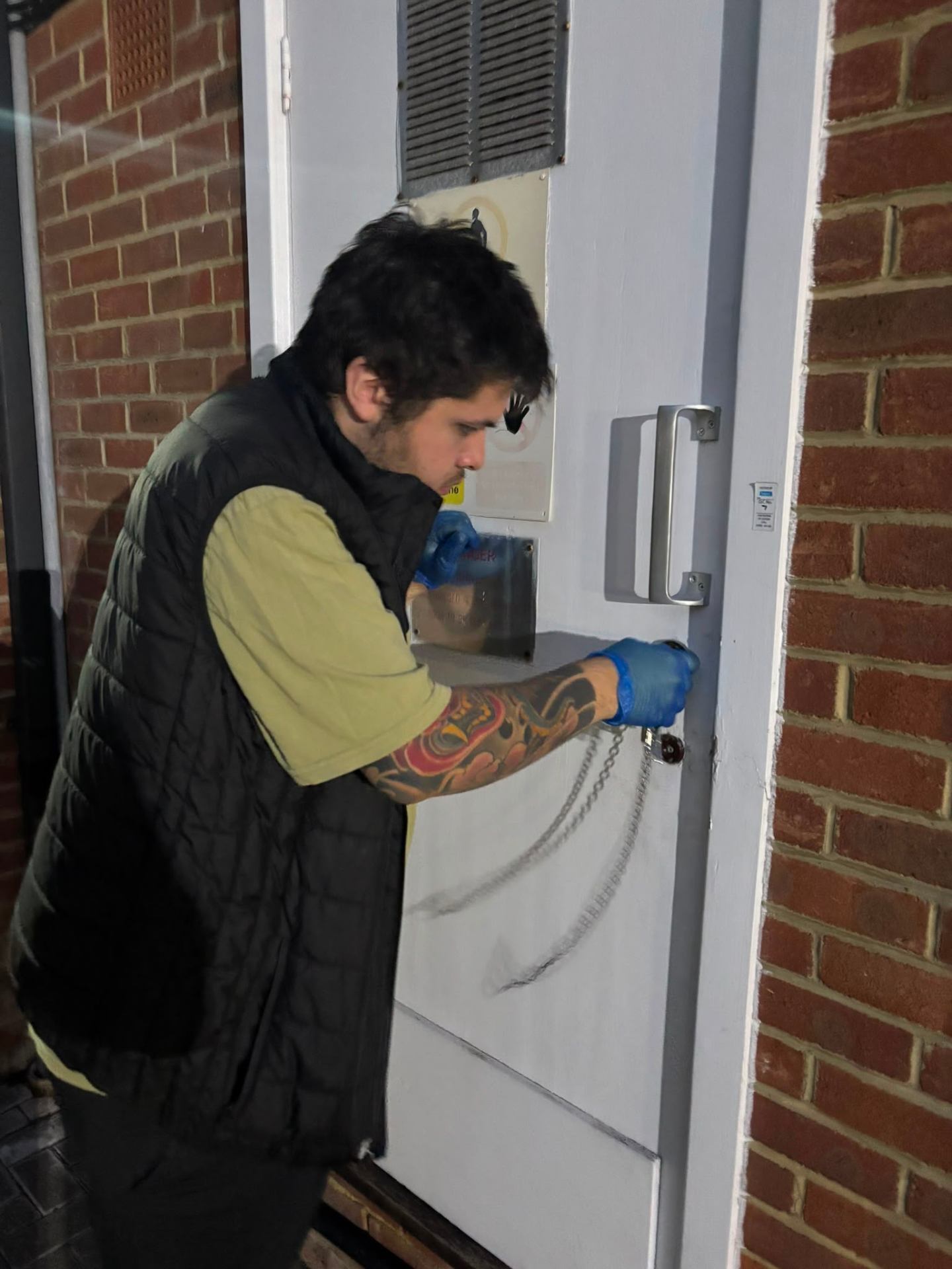 Electrician accessing a block of flats meter cupboard at night