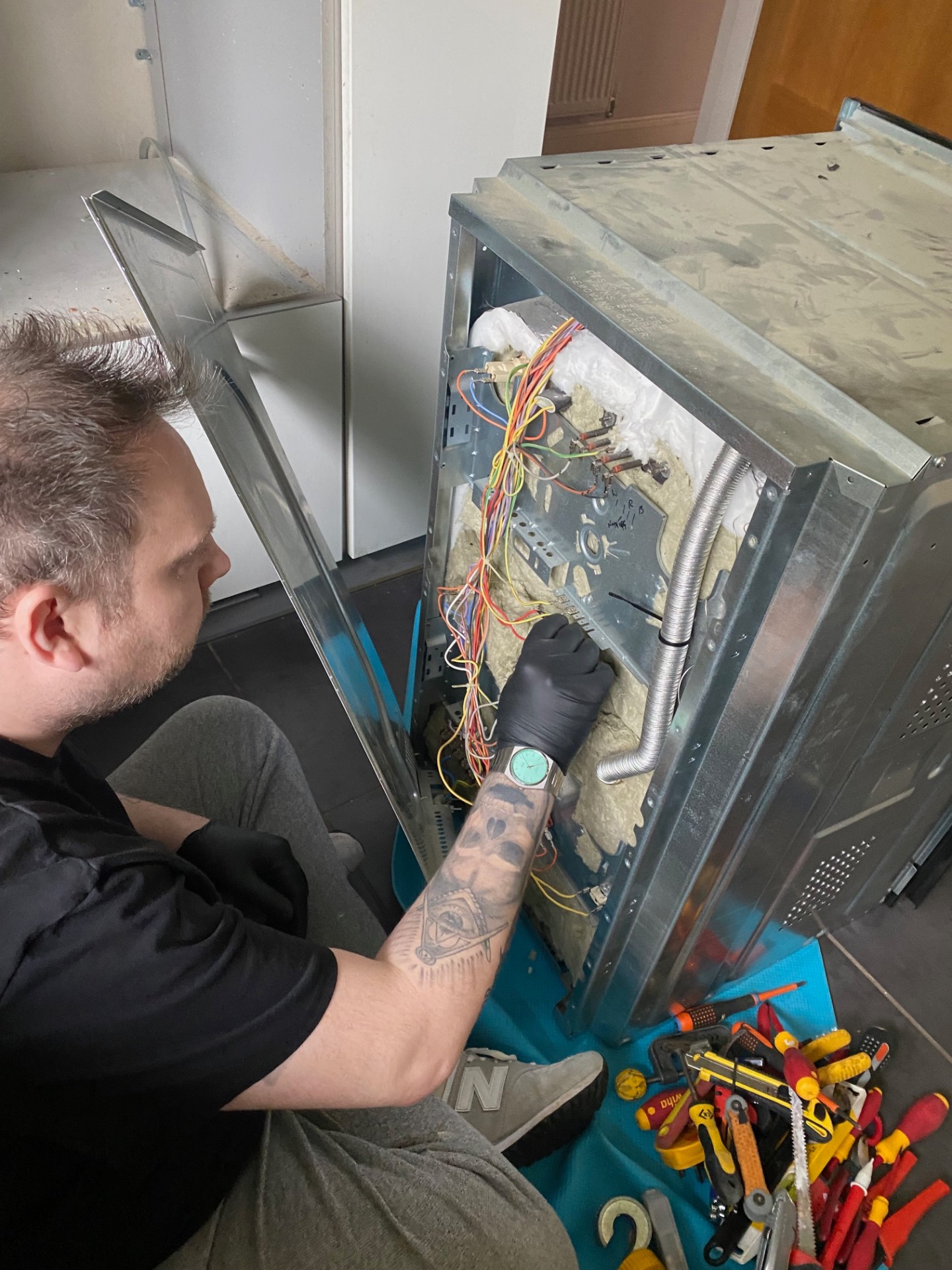 Engineer repairing domestic oven appliance