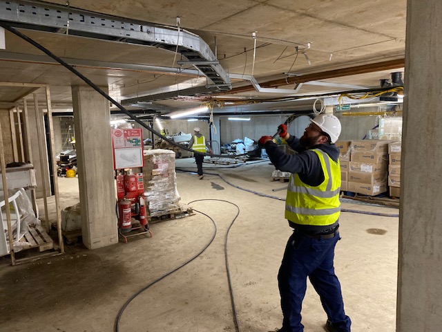 Engineer running cables on active construction site